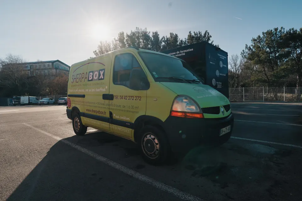 Véhicule utilitaire jaune garé devant le centre