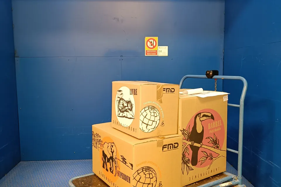 Cartons posés sur un chariot dans le monte-charge