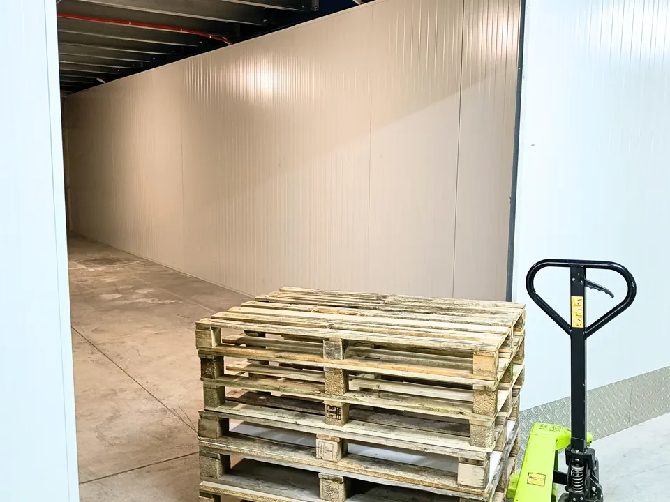 Très grand box de 48 m² avec des palettes et un transpalette