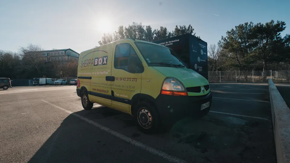 Véhicule utilitaire jaune garé devant le centre